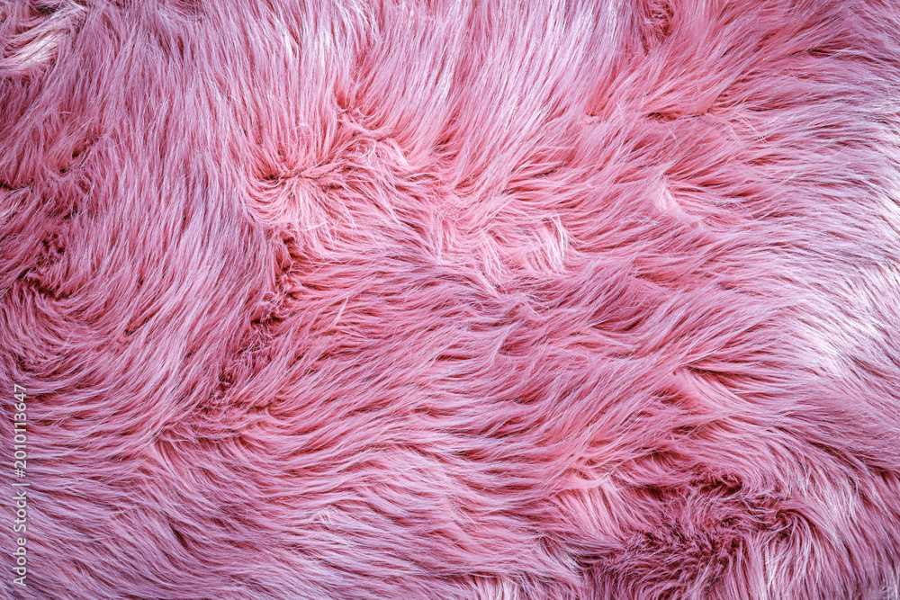 Fototapeta premium Soft pink fur texture on a fabric surface in a well-lit room