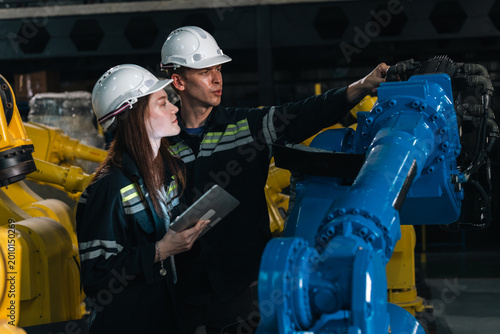Slika na platnu Repair specialist inspects machinery in factory ensuring industry standards are