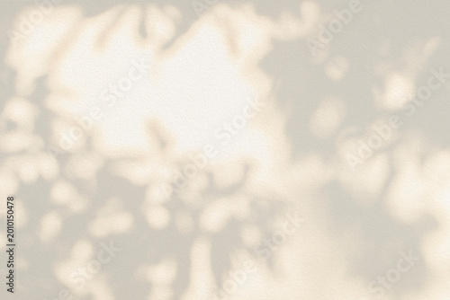 Leaf shadow and light beige background. Nature tropical leaves plant and tree branch shade with sunlight on wall texture for background wallpaper and design, shadow overlay effect