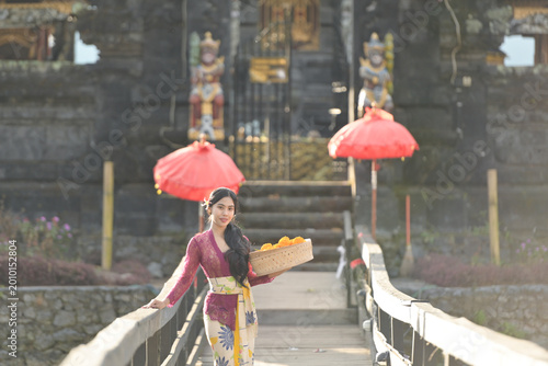 Bali Lady in Traditional dress walk in old temple, indonesia