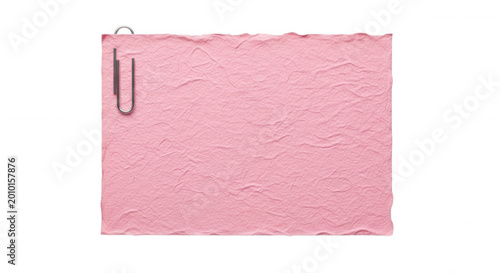 A rectangular sheet of textured pink paper with uneven edges, attached with a silver metal paperclip against a solid black background