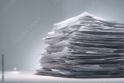 Pile of Documents: A towering stack of crisp white documents, representing the weight of paperwork.