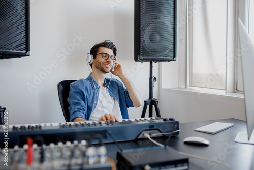 Tableau sur toile Male music arranger composing song on midi piano and audio equipment in digital recording studio