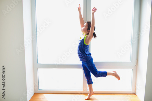 Φωτογραφία Little girl reaching up workout at home