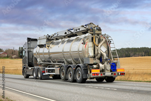 Truck Pulling Slurry Tank Trailer on Road, Rear View. 