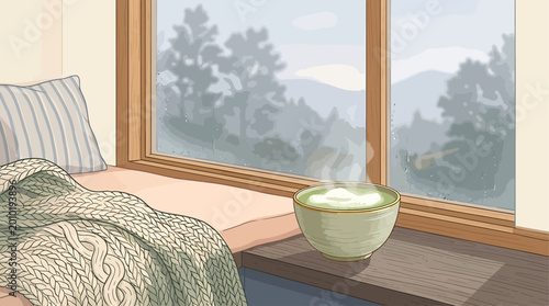 Cozy window seat with a steaming cup of matcha tea overlooking a misty mountain landscape on a cool day