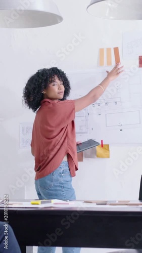 Vertical video: Starting review designer in rust top matching chips on iPad in studio picking tiles