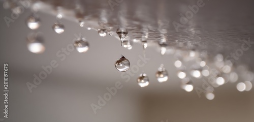 Close-up of water droplets falling from a shower head, creating a serene and refreshing atmosphere.