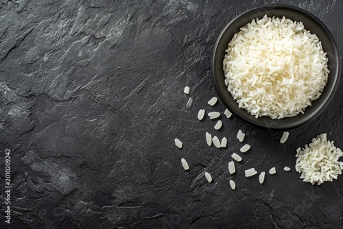White rice bowl on black slate background overhead view