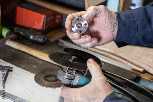 Tableau sur toile A skilled worker carefully assembles a metal locking nut onto an angle grinder w