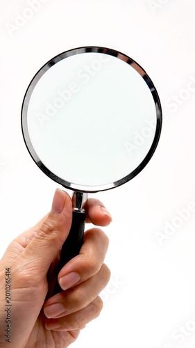 Hand holding a magnifying glass for examination and discovery