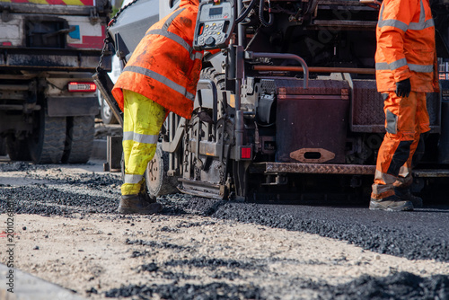 Obraz na plátne Workers lay asphalt on a construction site during the daytime to repair and main