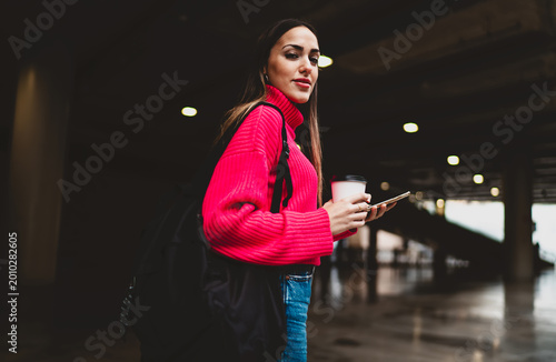 Photography Serious female entrepreneur with backpack walking up stairs in urban building, ambitious young woman holding coffee cup and looking away, digital nomad commute, financial freedom, copy space