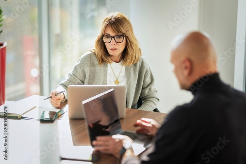 Group of business people having business meeting in a bright conference room