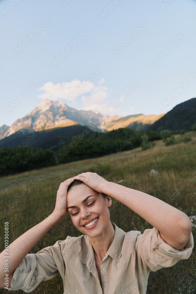 Obraz premium Meadow scene with a smiling woman in a beige shirt, hands on her head, sunlit grass swaying, conveying a relaxed outdoor lifestyle