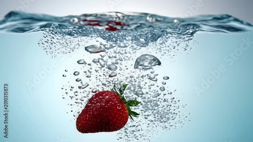 Strawberry Dropping into Water Creating Splash and Bubbles.