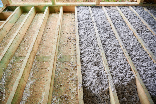 Fotografie Paper insulation fills floor cavities of timber frame house during construction