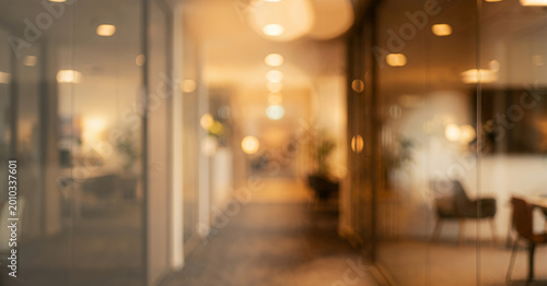 Φωτογραφία A softly blurred interior view of an office corridor, featuring modern decor, soft lighting and plants, creating a calm and inviting atmosphere