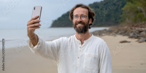 Male influencer taking a selfie on a tropical beach, enjoying vacation with social media content creation