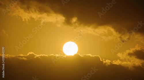 A beautiful spring dawn in Keelung, Taiwan, featuring the sun peeking through dramatic dark clouds in the morning sky.