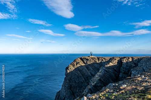 Foto Nordkapp cliff in Norway overlooking vast Arctic Ocean, iconic globe monument on