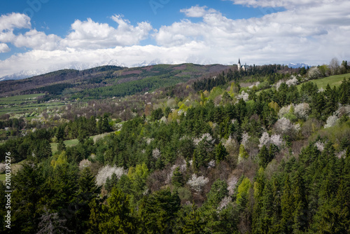 Breathtaking spring view of the Marianska hora pilgrimage site in Levoca, with the snow-capped High Tatras mountains in the background