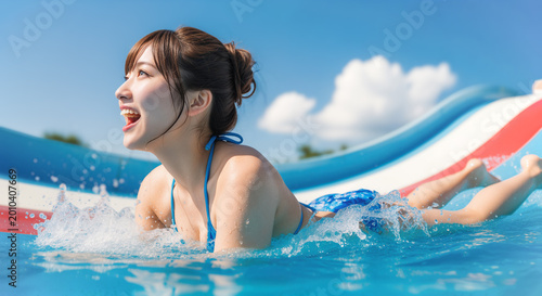 ウォータースライダーを滑る若い女性
