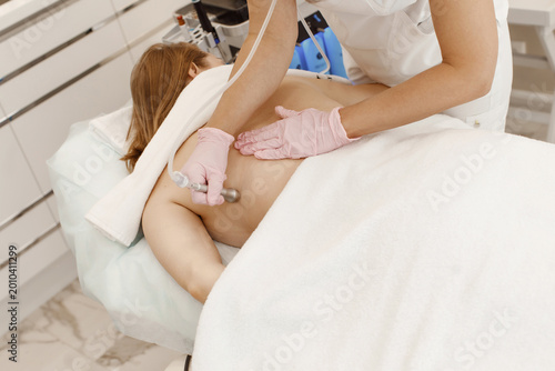 Professional female cosmetologist doing hydrafacial procedure in Cosmetology clinic.