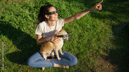 Принти на полотні Woman and dog enjoying solar eclipse viewing together