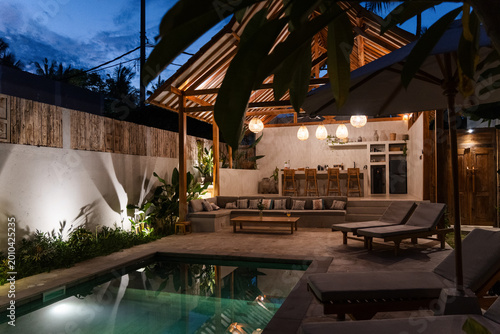 Photography Luxury villa patio with swimming pool and outdoor lounge during evening