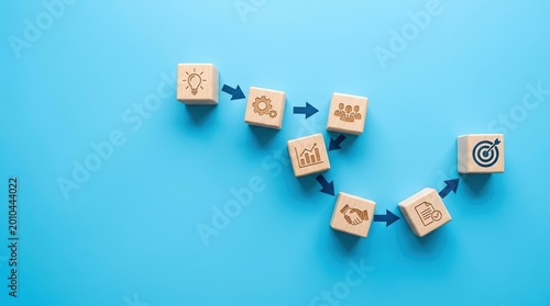 Business process concept illustrated by wooden blocks with icons and arrows
