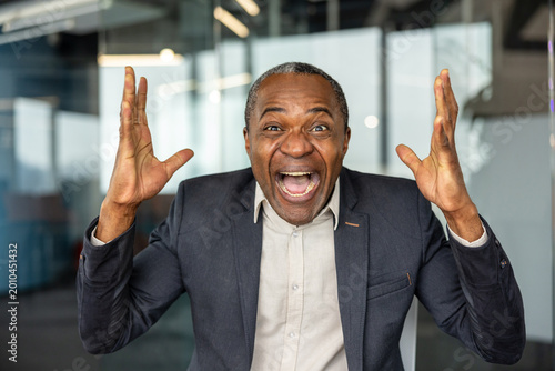 Quadro su tela Mature businessman experiencing joy and triumph, happily celebrating a significa