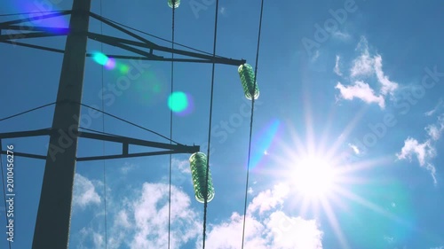 Electric Pole with Voltage, Electricity, Electric Grid, electrical energy for AI, cryptocurrency mining, Power Grid, Equipment and Beautiful Time Lapse of Clouds Sun and Pure Blue Sky.