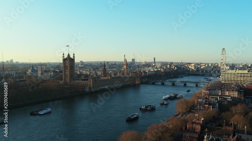 Elevated view from unique perspective of London skyline showing River Thames with boats, Westminster Palace, Big Ben, and London Eye during a sunny day