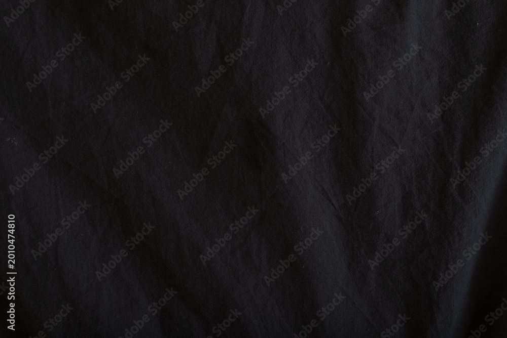 Fototapeta premium This scene features a dark fabric surface with a soft texture that displays subtle folds and shadows