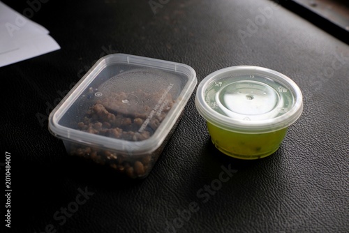 Close-up of plastic food containers with brown meat and
