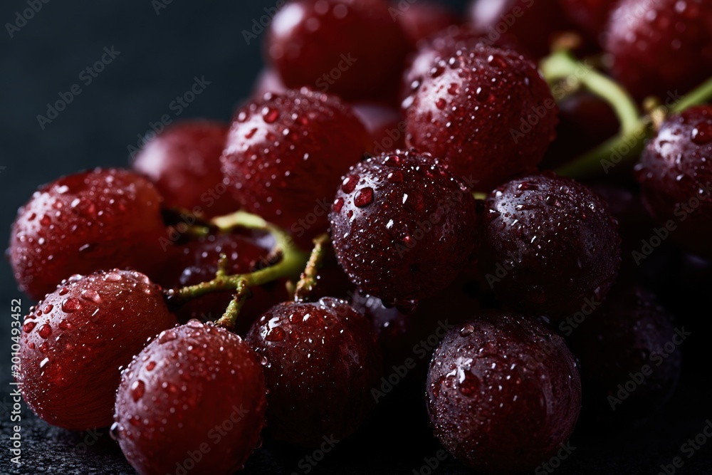 Naklejka premium Fresh red grapes with water drops on dark background