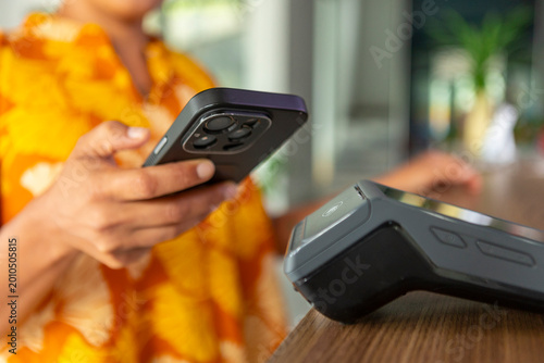 Person paying cashless using mobile phone in hotel
