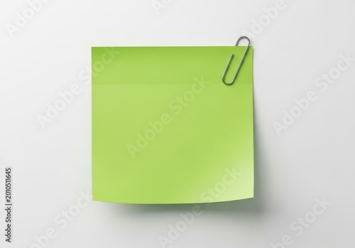 A lime green sticky note attached to a surface with a paperclip