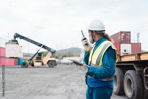 Tableau sur toile Senior logistics engineer supervising container lifting at cargo yard