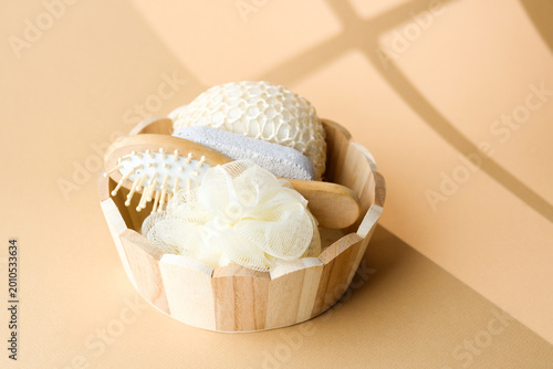 Bild auf Leinwand Wooden bowl filled with bath accessories including sponge pumice brush and loofa