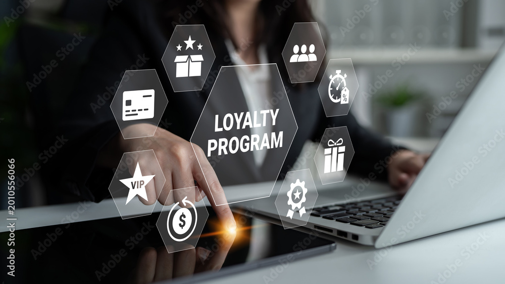 Naklejka premium A businessperson interacts with a laptop showcasing a digital loyalty program interface, symbolizing customer engagement and innovative business strategies for enhancing user experiences. Ledger