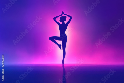 Silhouette of Woman practicing Yoga in tree pose against vibrant neon gradient background with glowing colors. Balance, Mindfulness, and Wellness. For Fitness, Meditation, Healthy lifestyle concepts