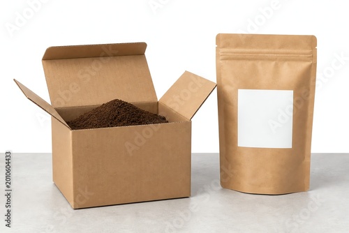 Open cardboard box filled with ground coffee powder and paper packet.