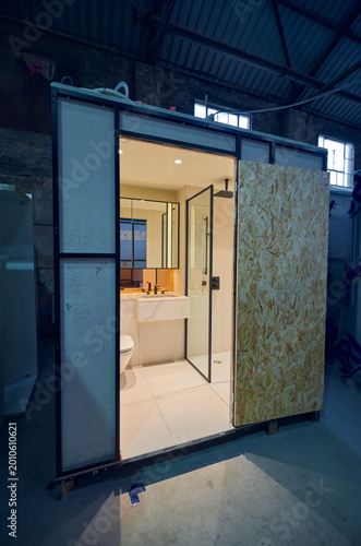 Prefabricated modular bathroom pod units in a factory with plumbing, sink, shower, bath and electrics installed ready for hotel and high rise apartment construction