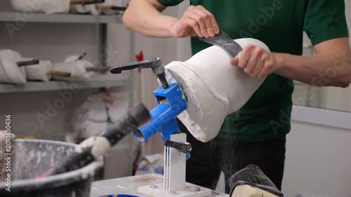 Prosthetic technician sanding a plaster mold for a custom limb