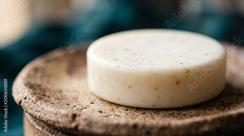 Solid waterless skincare balm sitting on textured ceramic dish in morning light