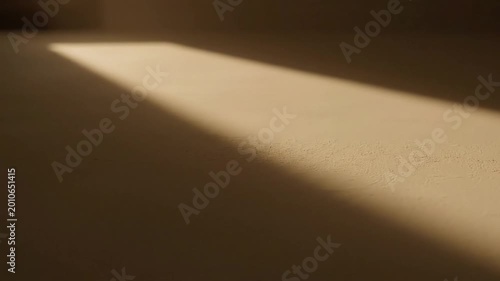 The movement of sunlight entering a room from outside.