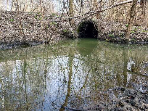 Photos Large reinforced concrete pipe installed under dirt road to prevent washout