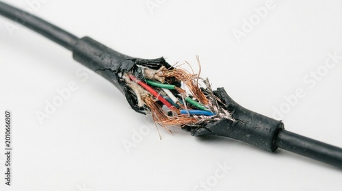 Damaged electrical cable with exposed wires and insulation  